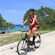 A woman riding an electric bicycle next to a beach in Cozumel, Mexico
